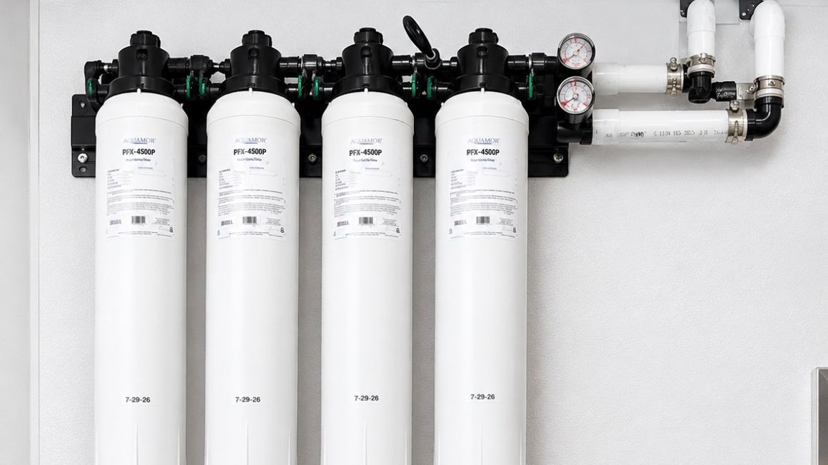 A wall-mounted Aquamor cartridge bank with four filters, isolation valves and inlet and outlet pressure gauges